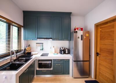 Modern kitchen with blue cabinets, appliances, and wooden accents