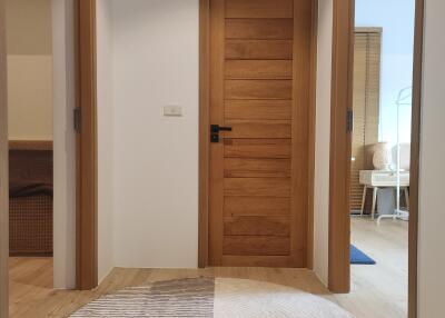 Wooden hallway with closed doors and a circular rug