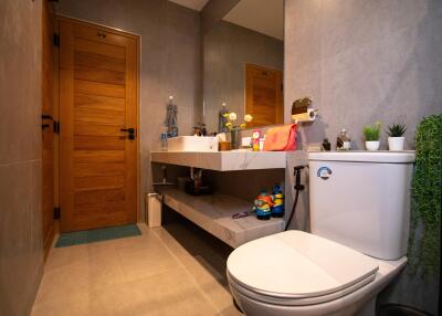 Modern bathroom with wooden door, large mirror, and sink