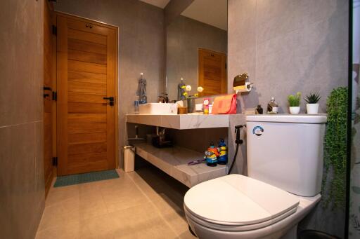 Modern bathroom with wooden door, large mirror, and sink