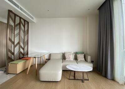 Modern living room with a white leather sectional sofa, glass dining table, and floor-to-ceiling curtains