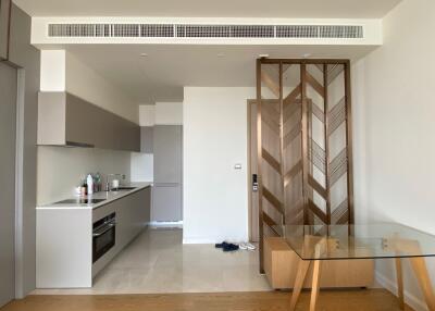 Modern kitchen area with integrated appliances and glass dining table