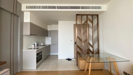 Modern kitchen area with integrated appliances and glass dining table