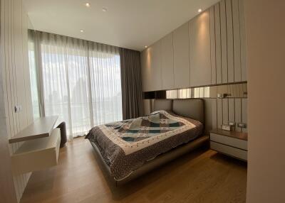 A modern bedroom with large windows and wooden flooring