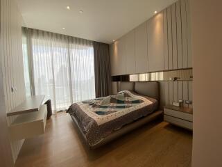 A modern bedroom with large windows and wooden flooring