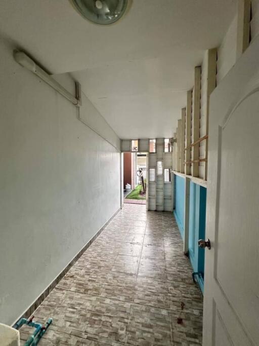 Long hallway with tiled floor leading to the outdoors