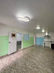 Spacious kitchen with green and white walls and tiled floor