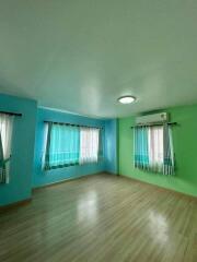 Bedroom with wooden floor, air conditioning, and large windows with curtains