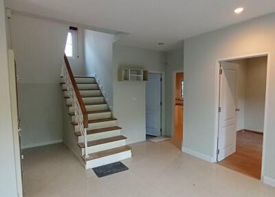 Spacious living room with staircase and open doorways