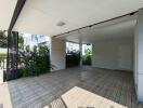 Covered carport with wooden flooring and garden view