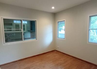 Empty room with wooden floor and two windows