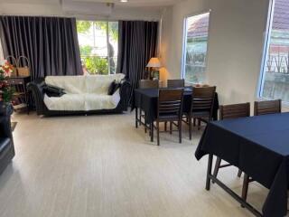 Bright living and dining area with black furniture and large windows