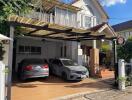 Two cars parked in a driveway in front of a house