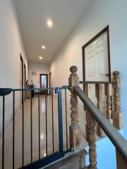 Bright corridor with wooden handrail and child safety gate