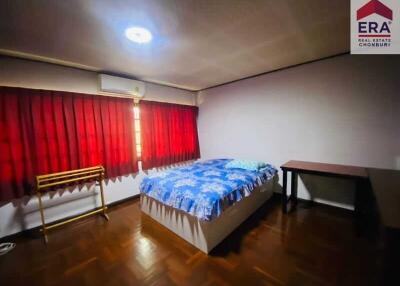 Bedroom with bed, desk, air conditioner, and red curtains