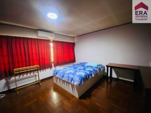 Bedroom with bed, desk, air conditioner, and red curtains