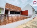 Photo of a building with a tiled roof and terrace