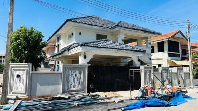 Two-story house with construction materials in the front yard