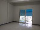 Spacious living room with large windows and white tiled floor