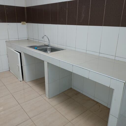 Simple kitchen with white tile countertops and backsplash