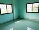 Empty bedroom with green walls and tiled floor