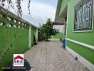 Paved backyard with green-painted walls and a small garden area.