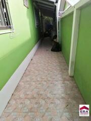 Outdoor hallway with green walls and tiled floor