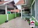 Front yard of a house with tiled flooring and greenery