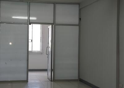 Modern office space with frosted glass partitions and tiled floor