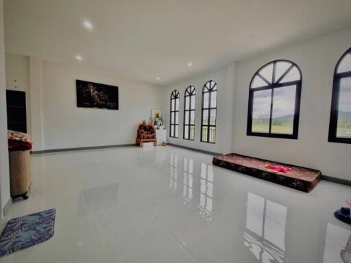 Spacious living room with large windows and glossy tiled floor