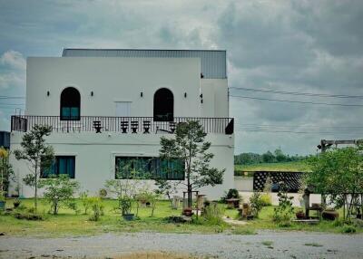 White two-story house with balcony and garden