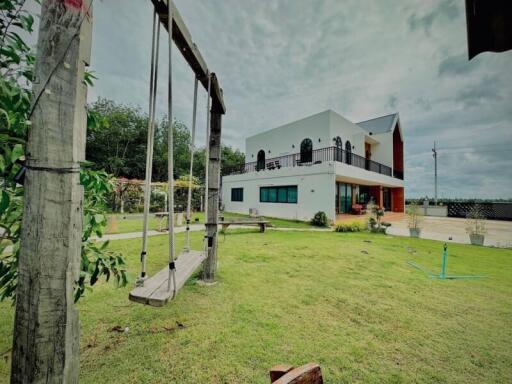 Modern two-story house with a swing in the garden