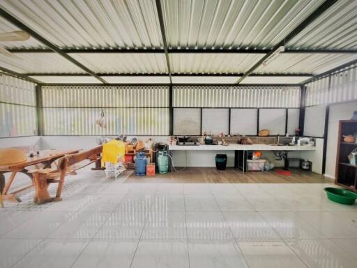 Outdoor kitchen area with appliances and large wooden table