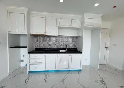 Modern kitchen with white cabinets, black countertop, and patterned backsplash