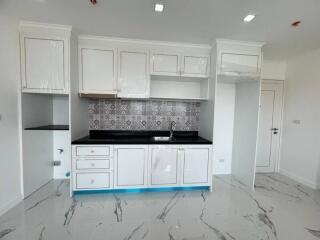 Modern kitchen with white cabinets, black countertop, and patterned backsplash