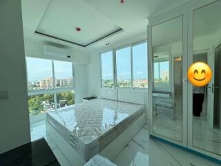 Spacious bedroom with large windows and city view