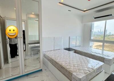 Modern bedroom with large windows, two single beds, and a mirrored closet