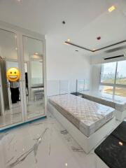 Modern bedroom with large windows, two single beds, and a mirrored closet