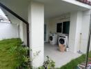 Outdoor laundry area with two washing machines and garden