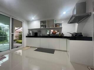 Modern kitchen with white cabinetry and black countertop