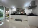 Modern kitchen with white cabinetry and black countertop