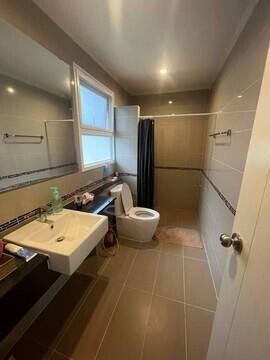Modern bathroom with sink, toilet, shower, and mirror