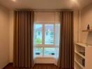 Well-lit bedroom with large window, curtains, and built-in shelves