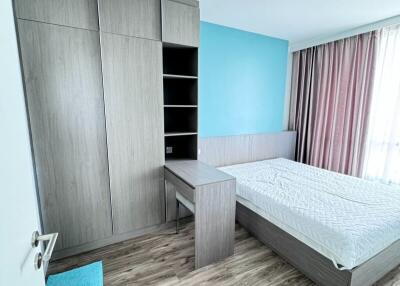 Modern bedroom with wooden floor, large wardrobe, study desk, and bed