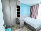 Modern bedroom with wooden floor, large wardrobe, study desk, and bed