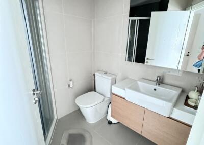 Modern bathroom with toilet, sink, and shower