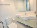 Modern bathroom with white fixtures and large mirror