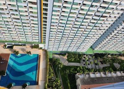 Aerial view of a modern apartment building with swimming pool and garden