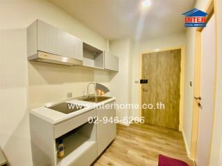 Modern kitchen with wooden flooring and compact cabinets