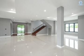 Spacious modern living room with large windows and staircase